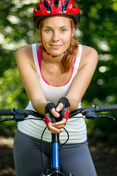 Happy Young woman leaned over the handlebars of her bike. - Photo, Image