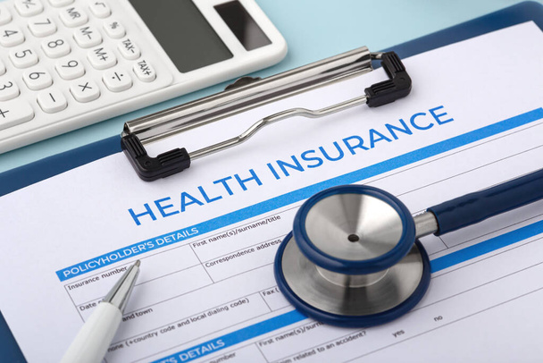 Health insurance document with stethoscope and calculator - 写真・画像