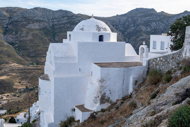 Church orthodox with cross, small white washed weathered old structure, climbed on rocky mountain at Serifos island, Cyclades Greece. Religious destination vacation summer sunny day nature background. - Fotografie, Obrázek