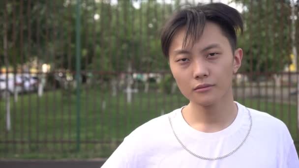 Egy fiatal ázsiai férfi portréja az utcán. Modern ifjúság - Felvétel, videó