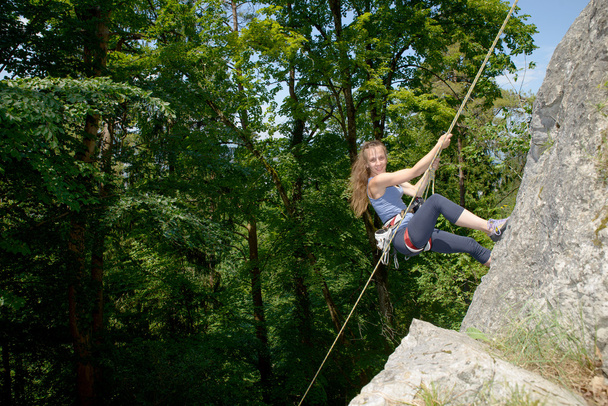 young woman climbing a rock wall - Photo, Image