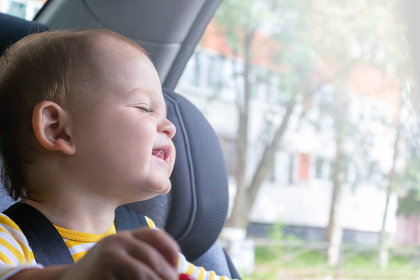 Happy baby boy sitting in car seat.  - Foto, Bild