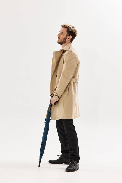 man in beige coat rain umbrella lifestyle posing - Fotoğraf, Görsel