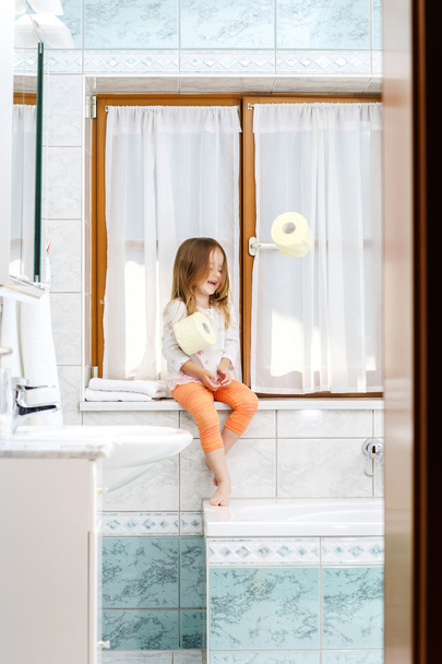 Cute little girl playing with toilet paper roll - Foto, imagen