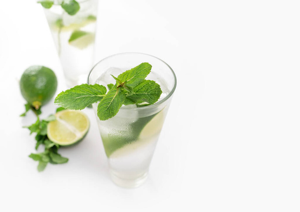 Cocktail Gin Tonic o Mojito in vetro con menta, ghiaccio, lime sullo sfondo bianco. - Foto, immagini