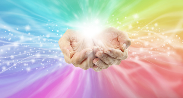 癒しの手と虹のエネルギーフィールド-コピースペースの両側に虹色の輝くエネルギーと白い光の流れに達する女性のカップ手 - 写真・画像