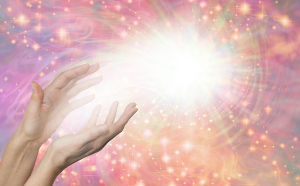 Sensing Scalar Healing Energy Field - Γυναικεία χέρια που φτάνουν μέχρι την μπάλα του λευκού φωτός σε ένα περιστρεφόμενο αφρώδες ροδάκινο και ροζ φόντο με αντιγραφικό χώρο - Φωτογραφία, εικόνα