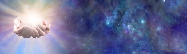 Divine Life Force Concept sky banner - mani coppate femminili con energia luminosa bianca oro brillante che emerge dallo sfondo blu del cielo stellato con spazio di copia sul lato destro                                - Foto, immagini