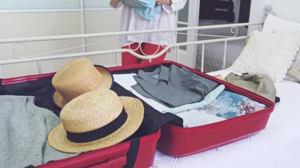 Female hand packs clothes in to the pink big suitcase for travel. - Filmagem, Vídeo