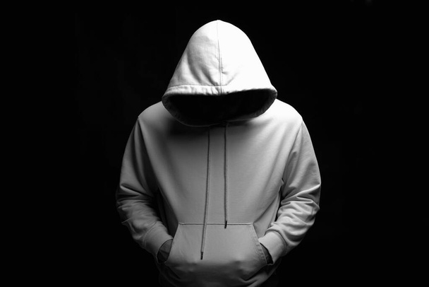 Ο άνθρωπος με το λευκό Hoodie. Αγόρι με κουκούλα που ποζάρει στο σκοτάδι - Φωτογραφία, εικόνα