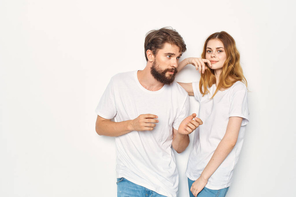 man en vrouw in witte t-shirts staan naast familie lichte achtergrond - Foto, afbeelding