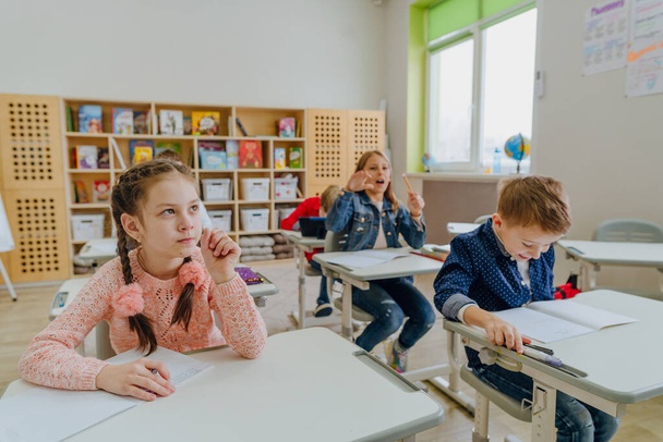 Pupils wearing casual clothes solving exercise in the classroom - Valokuva, kuva