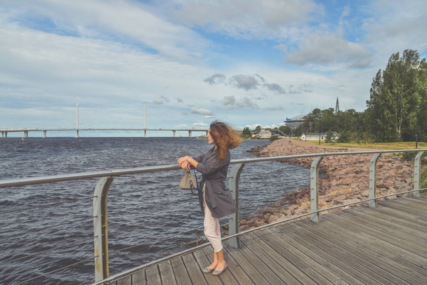 a girl on the embankment looks into the distance into the sea - Valokuva, kuva