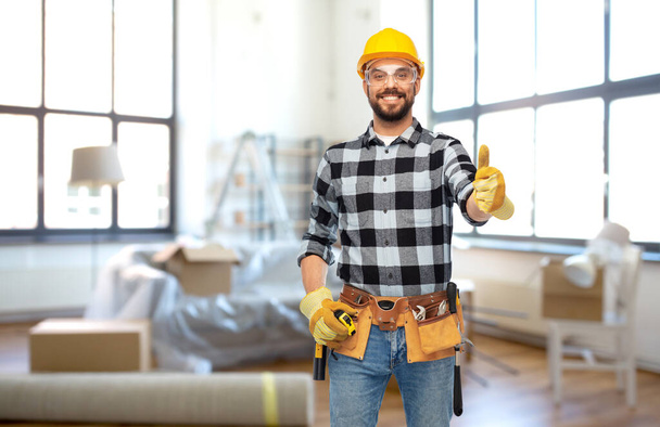 happy male builder showing thumbs up at home - Foto, Bild