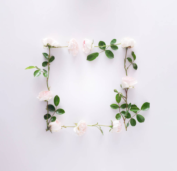 Romantic boho frame lay out made of white and pink roses on white background. Flowers pastel color with copy space. Wedding creative concept. Flat lay. Top view - Фото, зображення