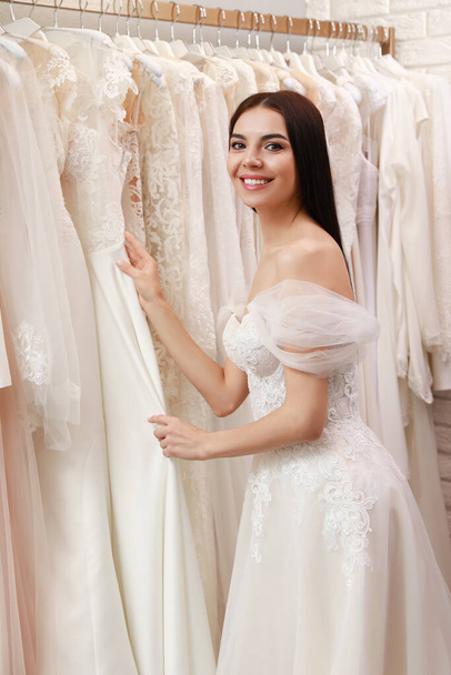 Young woman choosing wedding dress in salon - Foto, Imagen