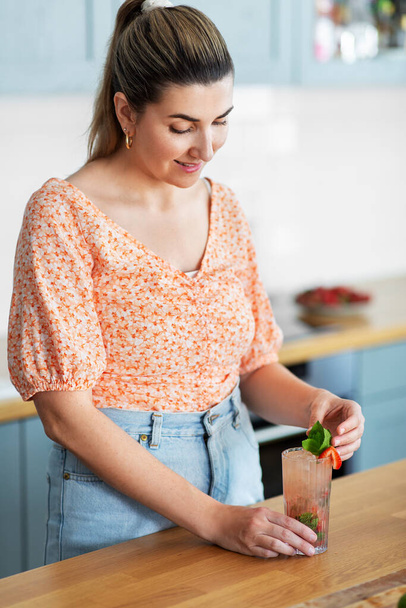 woman making cocktail drinks at home kitchen - Foto, afbeelding