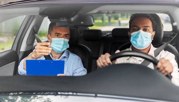 car driving school instructor and driver in mask - 写真・画像