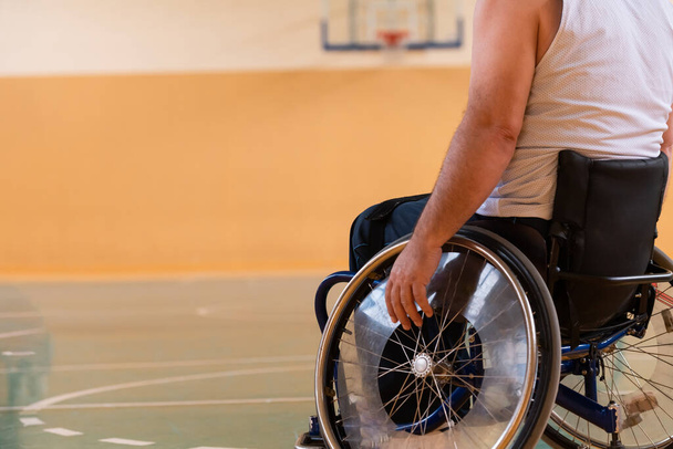 Close up photo of wheelchairs and handicapped war veterans playing basketball on the court - Foto, Imagen
