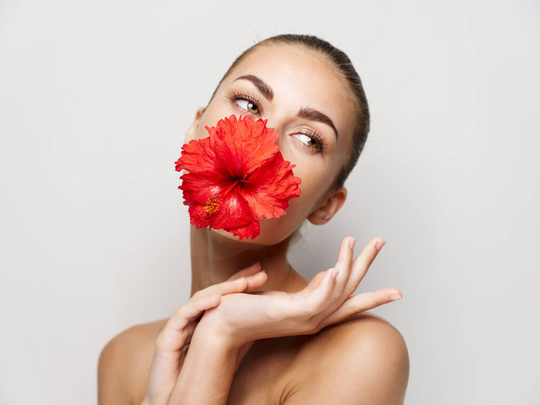 atraktivní žena s červenou květinou v ústech kosmetika glamor oříznutý pohled - Fotografie, Obrázek