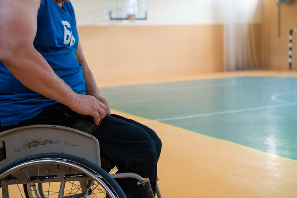 a handicapped basketball player prepares for a match while sitting in a wheelchair.preparations for a professional basketball match. the concept of disability sport - Fotografie, Obrázek