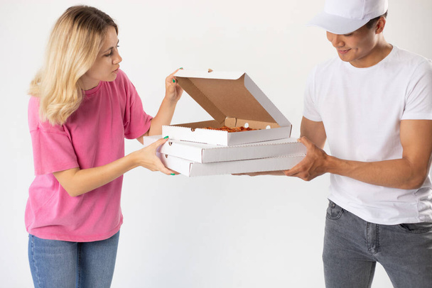 The delivery man gives the pizza to the client. - Foto, Imagen