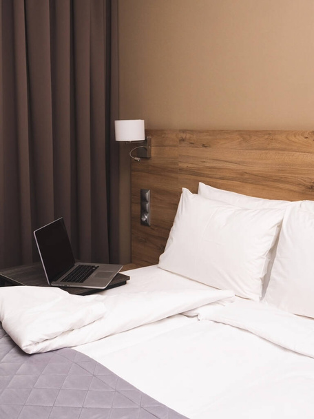 Moderne hotelkamer met kingsize bed en laptop - Foto, afbeelding