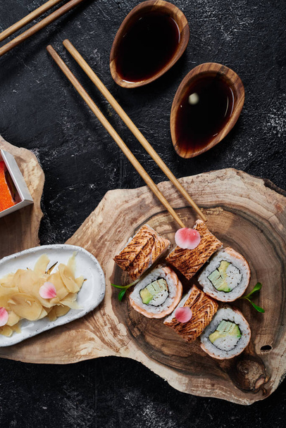Sushi roll with baked salmon on beautiful wooden cut. Top view. Banner. Space for text.  - Photo, Image
