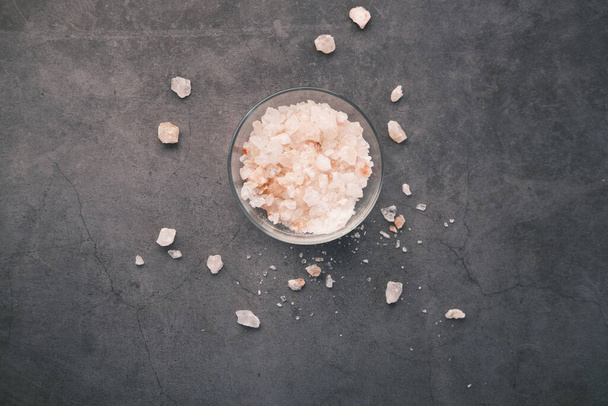 top view of pink rock salt in a bowl on black background  - Photo, Image