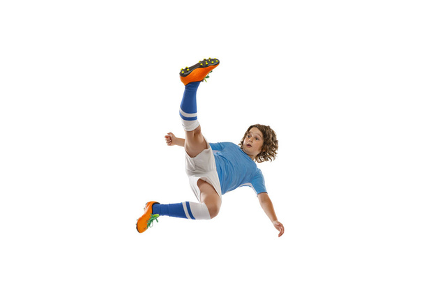 Flyer. Portrait of little male football soccer player, boy training with football ball isolated on white studio background. Concept of sport, game, hobby - Φωτογραφία, εικόνα