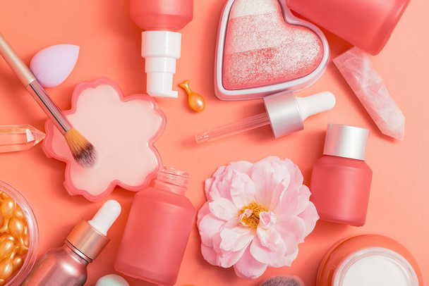 Produkty kosmetyczne. Różowe butelki i tuby z dozownikami, pipetą, rumieńcem w kształcie serca, pędzlami, kremem, esencją - Zdjęcie, obraz