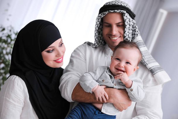 Happy Muslim family with little son indoors - Foto, imagen