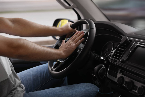 Man pressing horn in car, closeup. Aggressive driving behavior - Foto, immagini