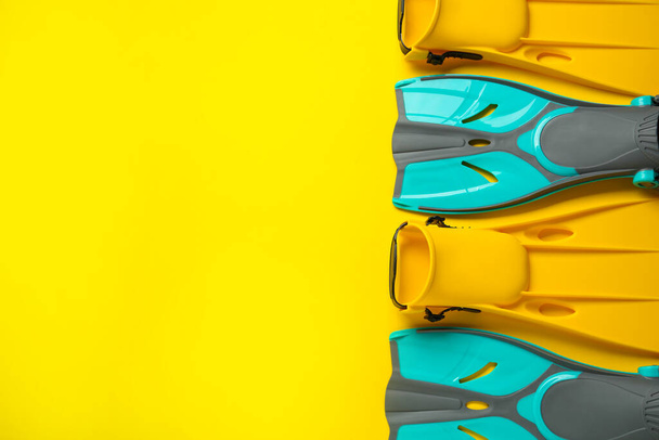 Different flippers on yellow background, flat lay. Space for text - Fotoğraf, Görsel