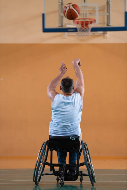 válka invalidní ve vozíčku s míčem v basketbalovém klubu při tréninku s profesionálním sportovním vybavením pro tělesně postižené. pojetí sportu pro osoby se zdravotním postižením - Fotografie, Obrázek