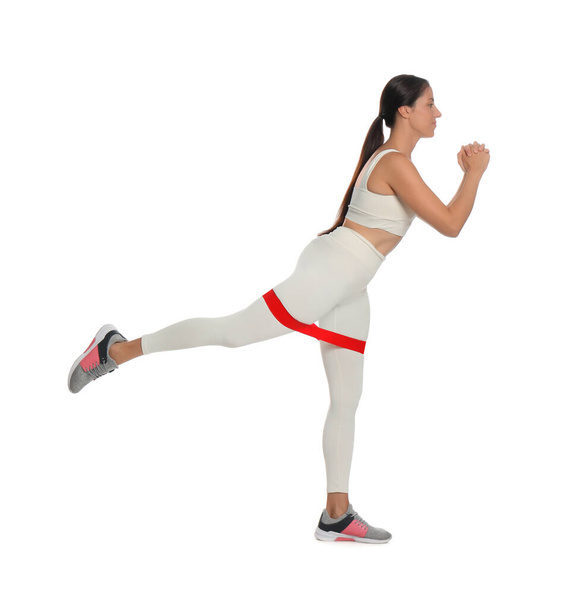 Woman doing sportive exercise with fitness elastic band on white background - Foto, Imagem