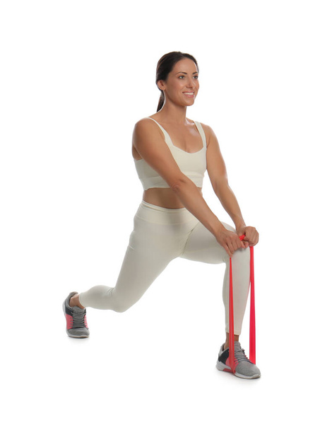 Woman doing sportive exercise with fitness elastic band on white background - Valokuva, kuva