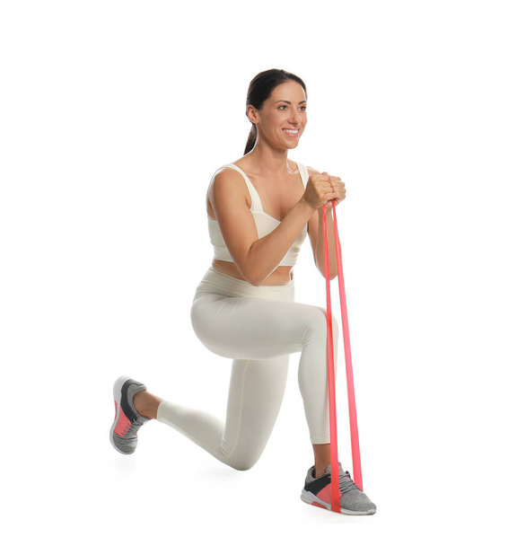 Woman doing sportive exercise with fitness elastic band on white background - Foto, imagen