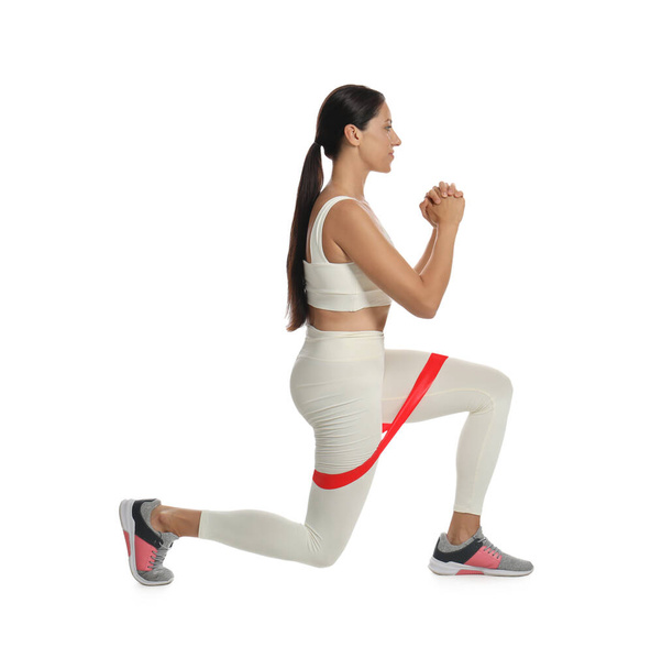 Woman doing lunges with fitness elastic band on white background - Fotografie, Obrázek