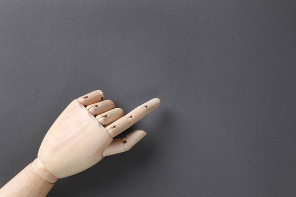 Wooden mannequin hand on grey background, top view. Space for text - Φωτογραφία, εικόνα