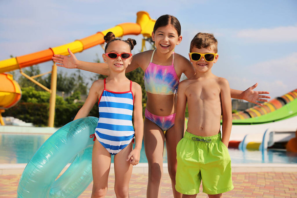 Cute little children with inflatable ring near pool in water park - Photo, Image