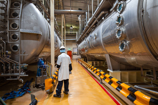 Proceso de inspección de trabajo masculino bodega de leche en polvo en la fábrica de tanques horizontales de acero inoxidable - Foto, imagen