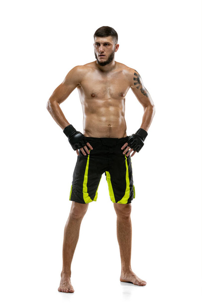 Full-length portrait of Caucasian athlete, professional male MMA boxer isolated on white studio background. Sport, competition and human emotions concept. - Foto, afbeelding