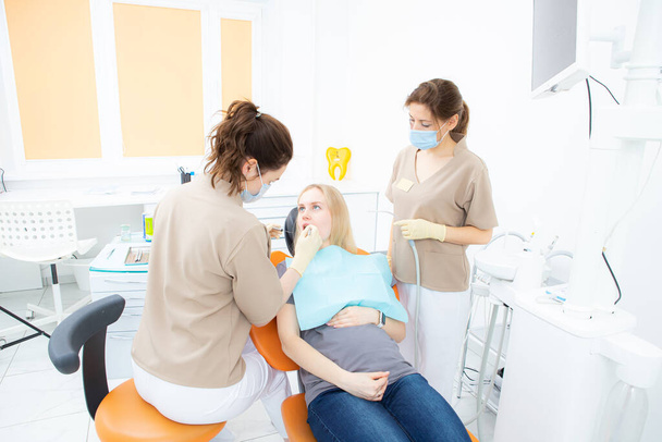 pregnant woman at the dentists office, checkup and dental treatment for pregnant women. - Фото, изображение