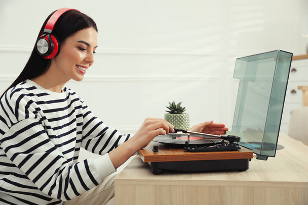 Женщина слушает музыку с проигрывателем дома - Фото, изображение