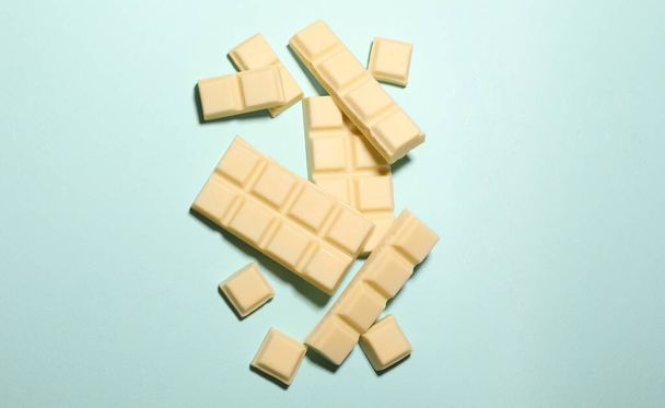 Herkullinen valkoinen suklaa turkoosi tausta, ylhäältä. Tekstitila - Valokuva, kuva