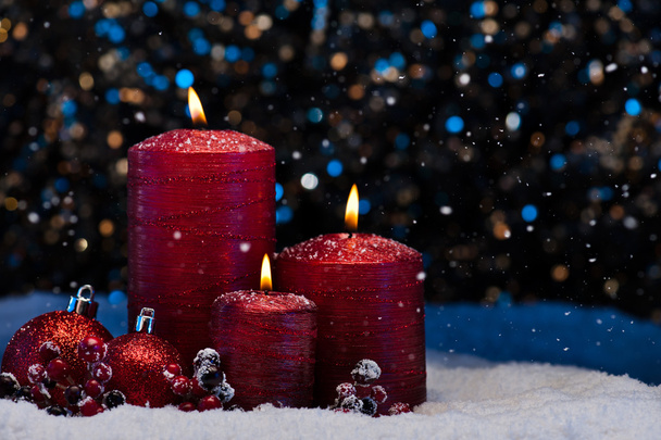 Tre candele rosse nella neve
  - Foto, immagini