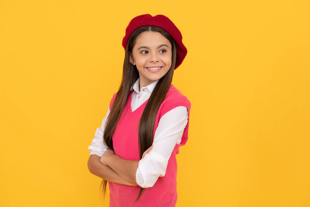 feliz adolescente escolar en boina francesa sobre fondo amarillo, sonrisa - Foto, imagen