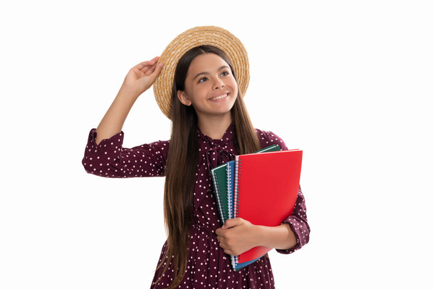 Saman şapkalı mutlu çocuk okul defterini beyazlar ve okullarda izole bir şekilde okumak için tutuyor. - Fotoğraf, Görsel