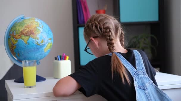 Visão rara da menina ruiva com óculos estudando em casa, fazer lição de casa - Filmagem, Vídeo